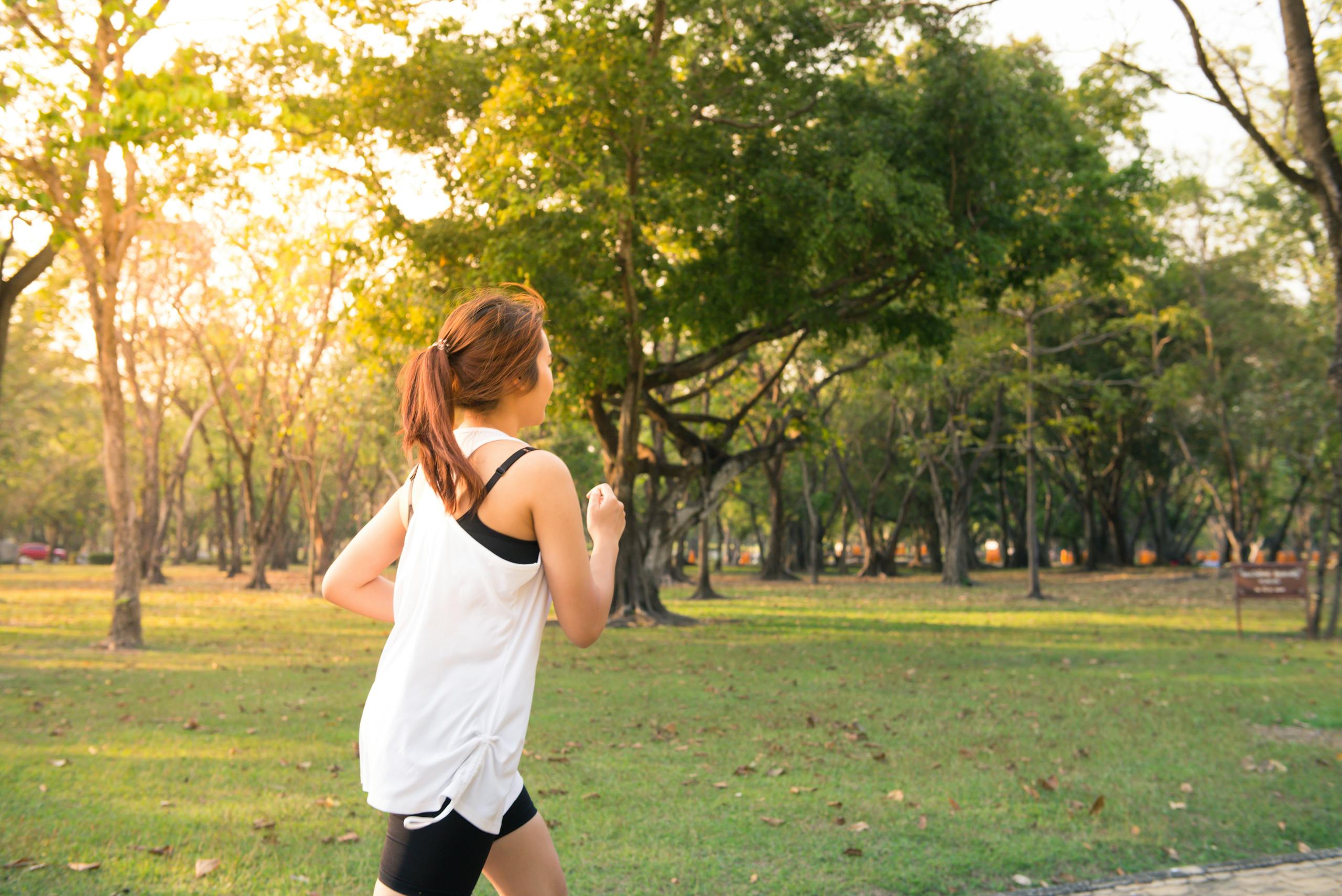 une femme qui pratique un sport, la course à pied, dans un parc